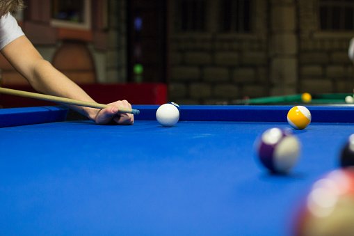 Pool player aims to shoot balls with cue