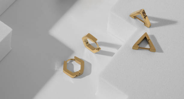 istock Geometric shape golden earrings on white background with copy space 1403525146