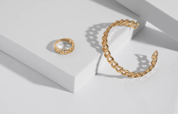 Chain shape golden modern bracelet and ring on white podium with copy space Chain shape modern bracelet and ring on white podium with copy space jewelry box photos stock pictures, royalty-free photos & images