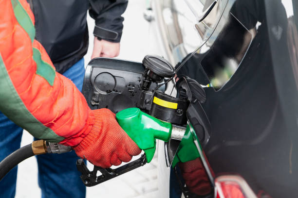 istock process of refueling car by employee in red jacket 1403525317