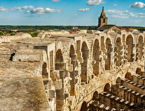 The view over the stone colonnade that surrounds the old Roman arena at Arles includes some church spires from the city.