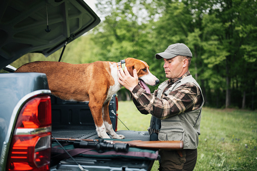 Man preparing for a hunt with his hunting dog.