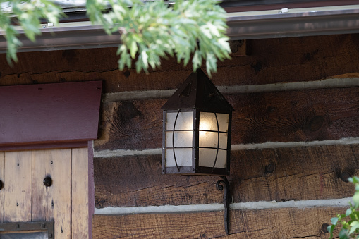 Antique outdoor lamp on log building in Montana in northwestern USA.