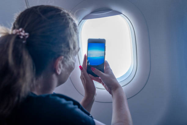 istock Young woman taking a picture on an airplane 1403528959