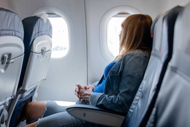 istock Woman looking through window in airplane 1403529104