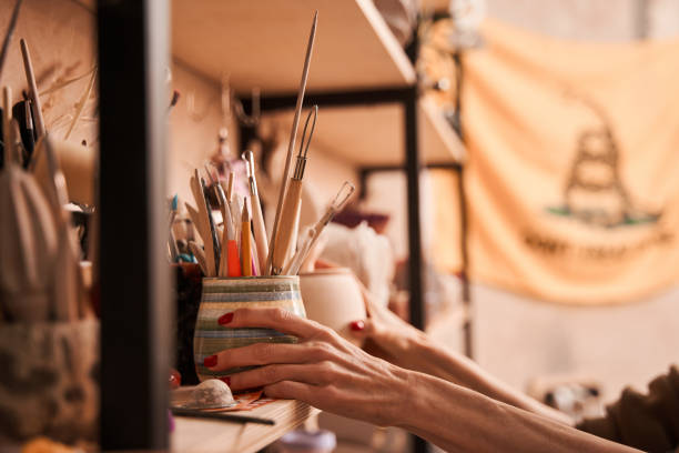 istock Female artist putting jar with brushes at the shelves while preparing drawing 1403529747