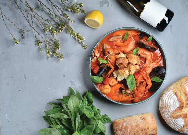 a dish of italian cuisine caciucco. tomato soup with seafood and herbs on a gray table, top view - basil tomato soup food and drink imagens e fotografias de stock