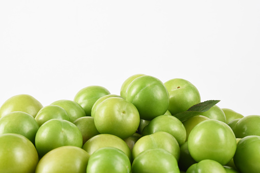 Front view group of green plums on the white background with copy space