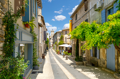 A narrow street of cafes and shops in the historic center of Saint-Rémy-de-Provence in the Provence region of Southern France.