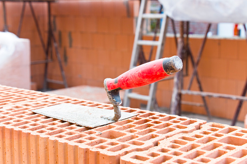 Trowel on bricks at a construction site of a new family home