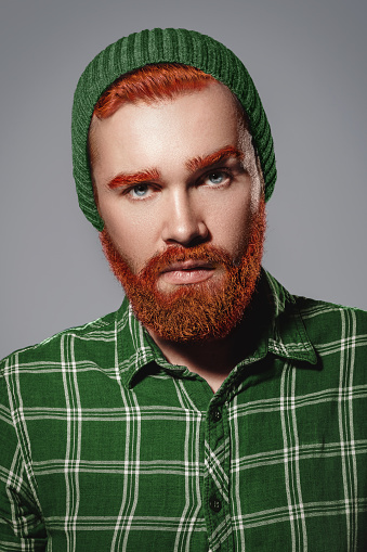 Portrait of handsome red hair bearded man wearing gingham shirt