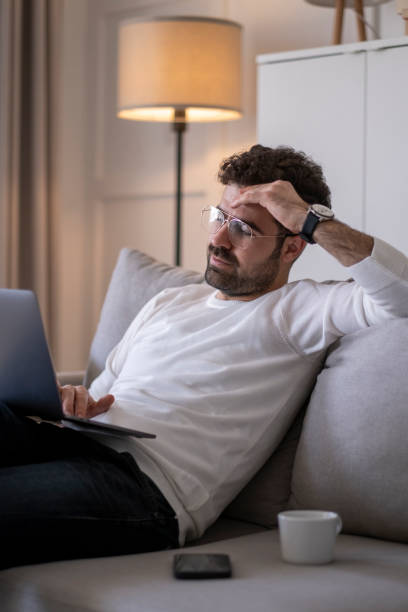 istock Businessman sitting on sofa working on laptop computer. 1403540058
