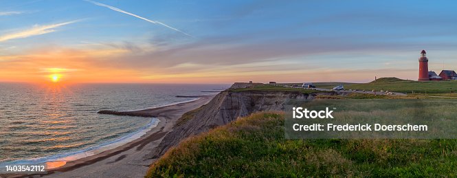 istock Panoramic view of the cliffs at the danish coast with the red lighthouse Bovbjerg Fyr. Panoramic view of beautiful nature landscape at the Danish North Sea coast, Jutland, Denmark, Europe. 1403542112