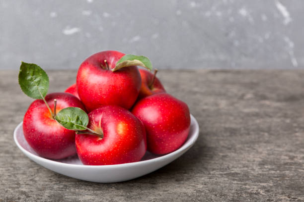 istock juicy red apples in a bowl or plate on the table top view. Copy space 1403551845