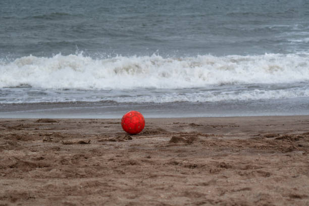 istock a red ball on the sand in a beach. 1403551926