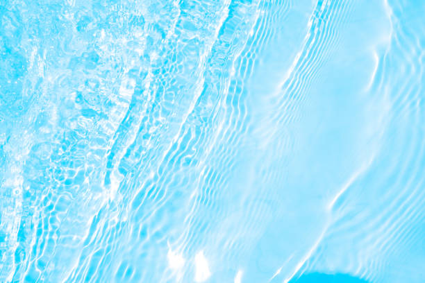 istock Blurred transparent blue colored clear calm water surface texture with splashes and bubbles. Trendy abstract nature background. Water waves in sunlight. water background 1403553645