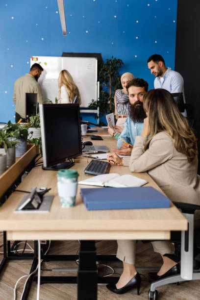 istock Full length shot of young people co-working on various projects in a modern office space 1403555100