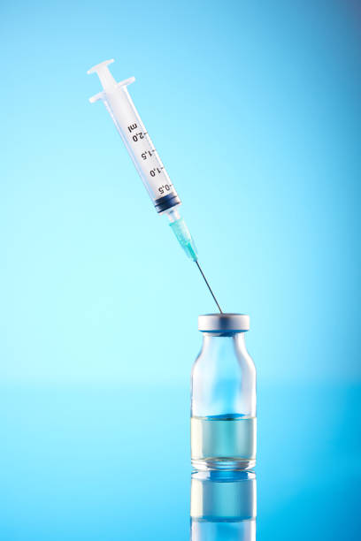 istock Coronavirus Vaccine: Syringe And Vials On Blue Background 1403555755
