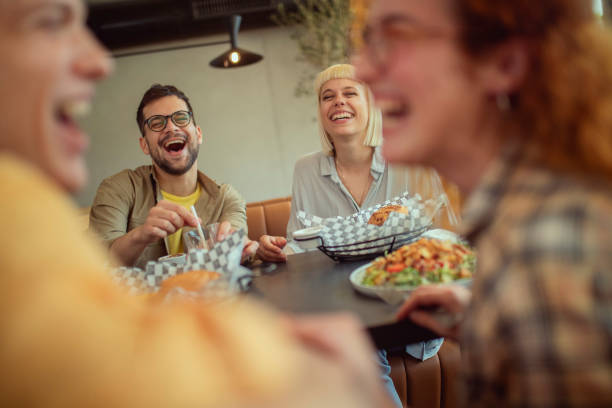 istock A small group of people are having crazy fun while having lunch at a restaurant. 1403555768