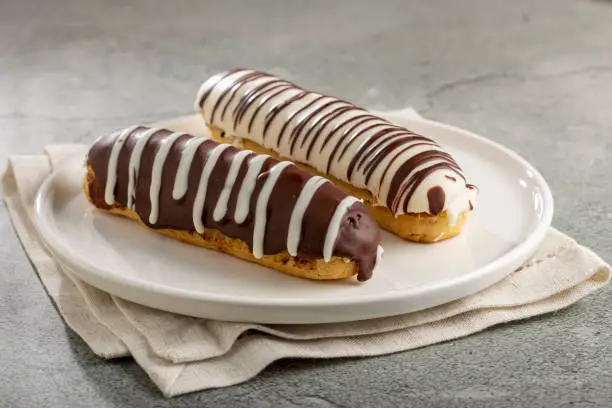Eclair. Tasty chocolate eclair on the table.