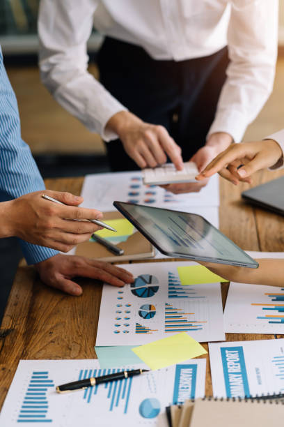 istock Business people discuss investment project working and planning strategy on digital tablet. Business people talking together with tablet at office. 1403575235