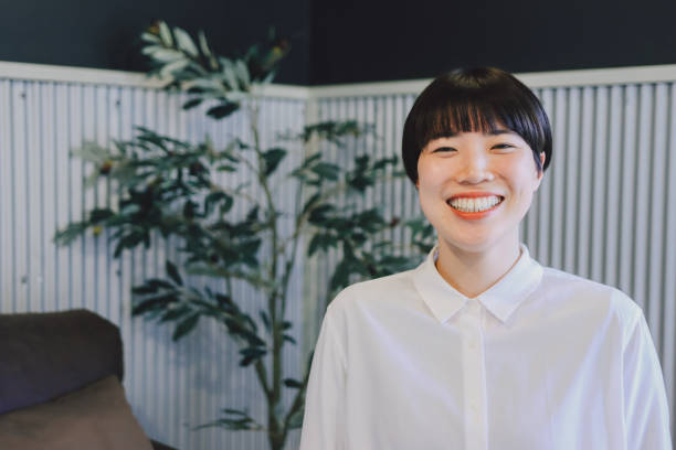 Asian woman smiling and laughing in an office setting stock photo