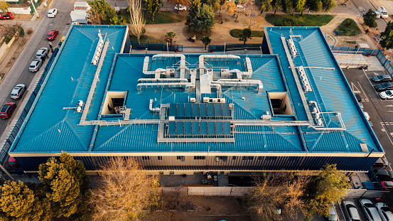 Aerial drone view of the architecture of a CESFAM Medical Center with a blue roof