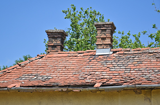 A moss-covered intermediate roof over a building entrance.\