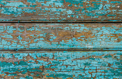 old boards as an abstract wooden background, painted with green paint that peels off