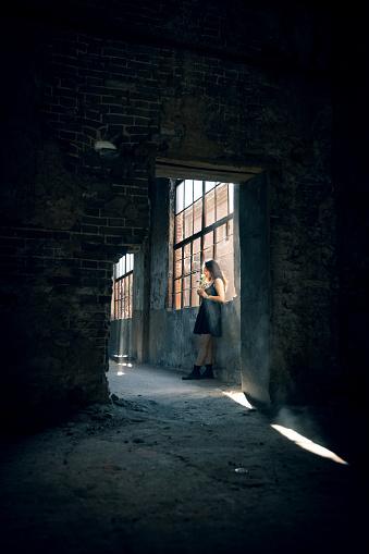 Women holding a rose standing in a ruins