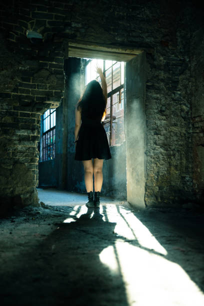 istock Woman in a destroyed building looking sunlight 1403601833