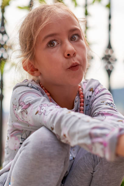 Emotional portrait of a young girl looking straight at camera Close up emotional portrait of a young girl sad girl crouching stock pictures, royalty-free photos & images