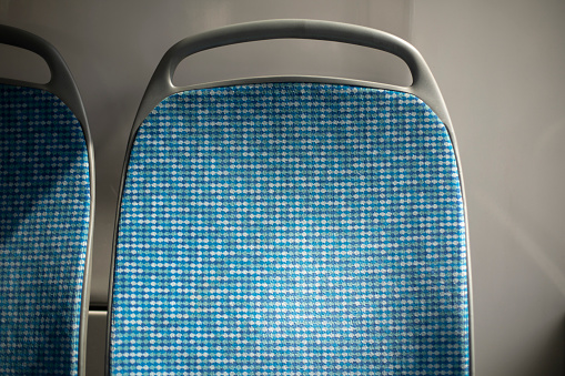 Seat on bus. Back of seat in transport. Public transport in detail. Interior of bus.