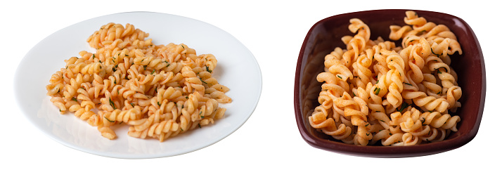 pasta on  white and brown  plate isolated on white background. pasta in tomato sauce with dill. pasta top view