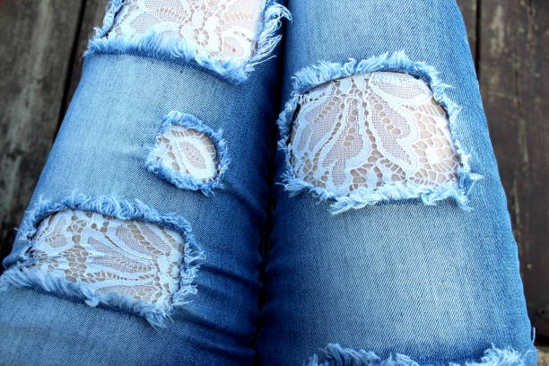 Women's legs in abstract jeans trimmed with guipure.