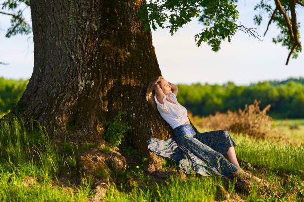 istock Young woman posing at sunset by an oak tree 1403608907