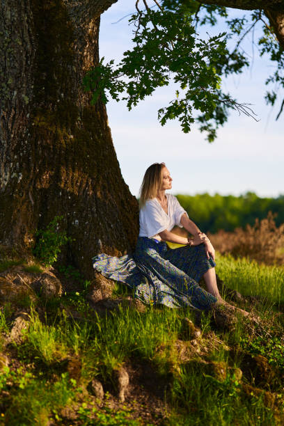 istock Young woman posing at sunset by an oak tree 1403608908