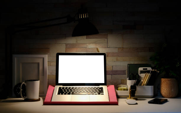 istock Home office mockup laptop with empty display, coffee cup, books and picture frame on white table.