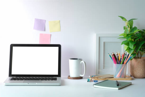 istock Comfortable workspace with laptop, coffee cup, potted plant and stationery decorations on white table. Home office. 1403609778
