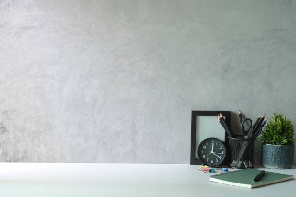 istock Stylish workplace with picture frame, stationery and potted plant on white table. Copy space. 1403609787