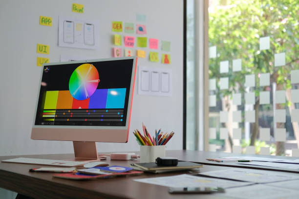 istock Creative designer workplace with modern computer, paperworks and stationery on wooden table. 1403610052