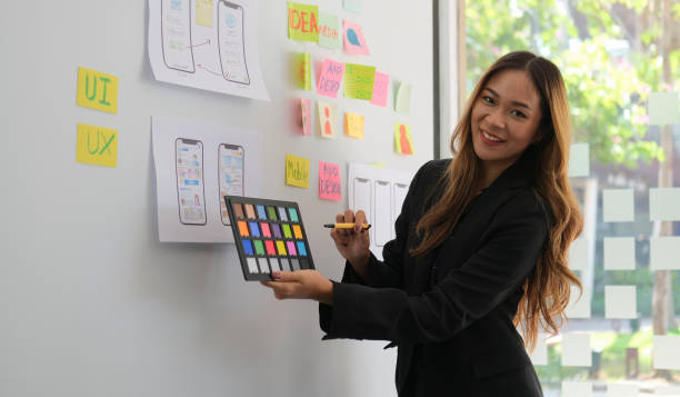 istock Smiling creative woman planning application for mobile phone on whiteboard. 1403610113