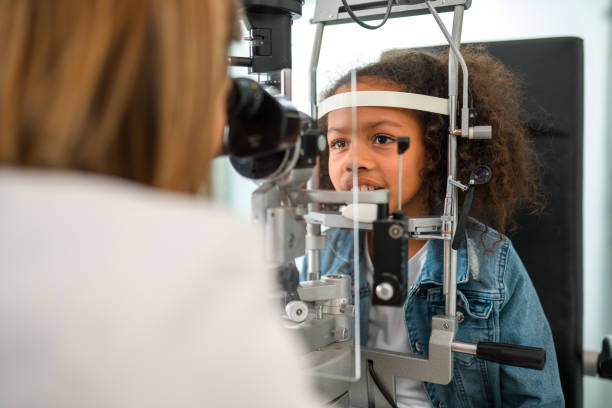 istock Black Child Looking into Eye Doctor who Inspects her Vision Quality 1403610205