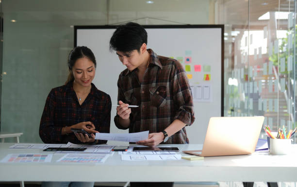 istock Group of web designers are working together to develop mobile responsive website together at modern workplace. 1403610232