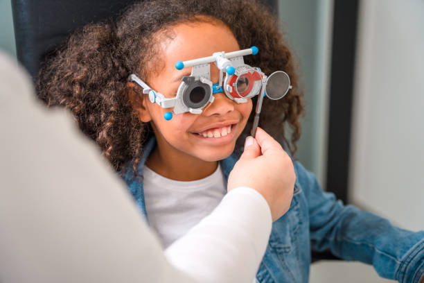 istock Curly Hair Smiling Child Having an Eye Test with Mature Optometrist 1403610933