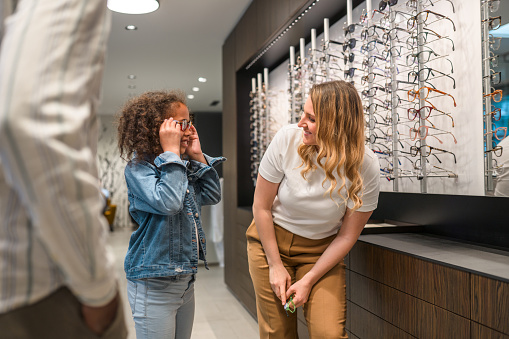 Excited little girl with female optician. They are looking at each other in agreement.