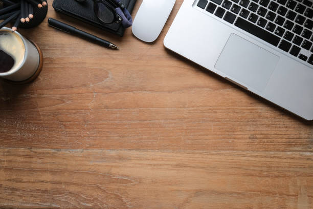 istock Top view simple workplace with laptop computer, coffee cup, glasses and notebook on wooden table. Copy space. 1403611024