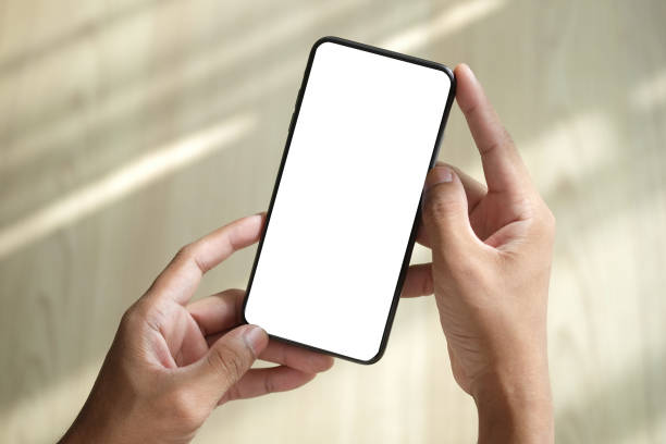istock Close up view man hands holding smart phone with blank screen for advertise text, information content. 1403611212