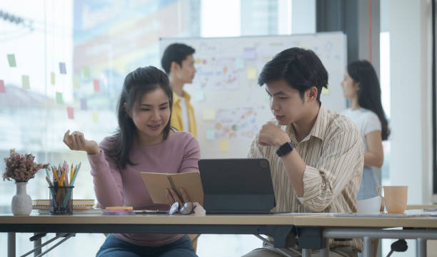 istock Young businesspeople discussing creative project together at bright office. 1403611428