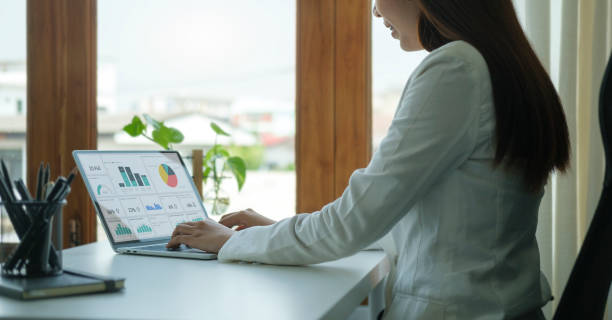 istock Young asian female office worker sitting in bright office and working on computer laptop.